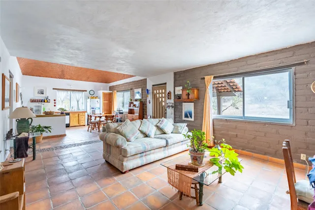 a bedroom with two beds and next to a window