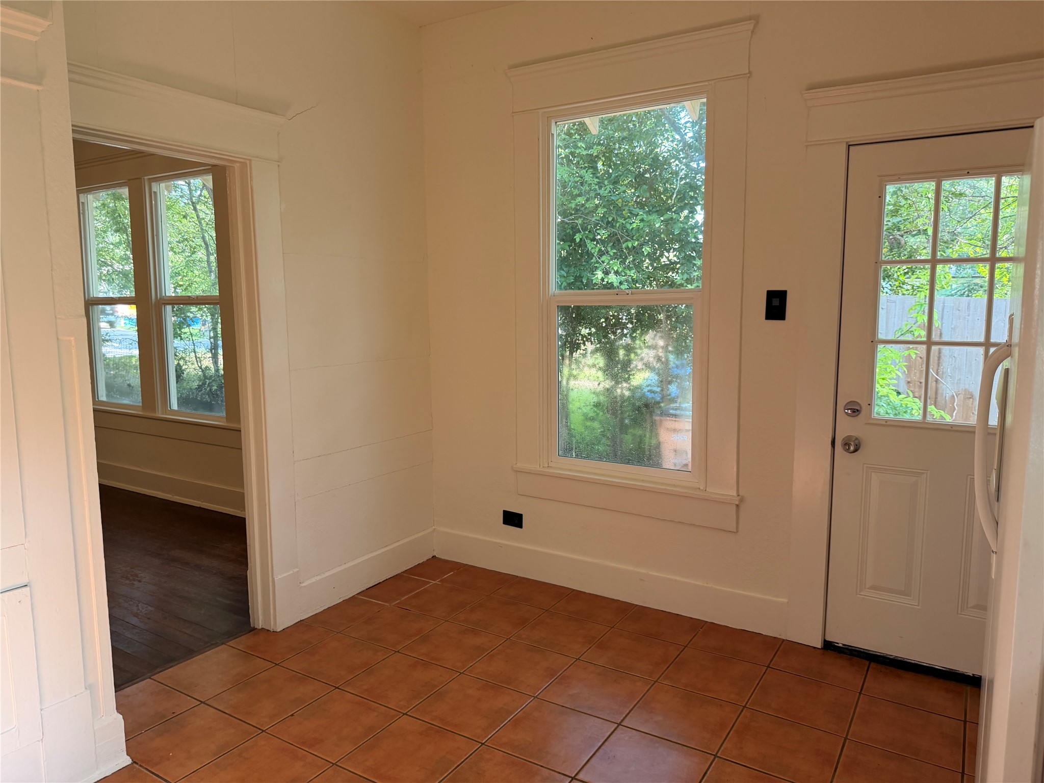 1136 Eleanor Street Austin, TX 78721 - Photo 7 of 30 A well-lit area features warm tile flooring and classic white trim, creating a welcoming atmosphere.