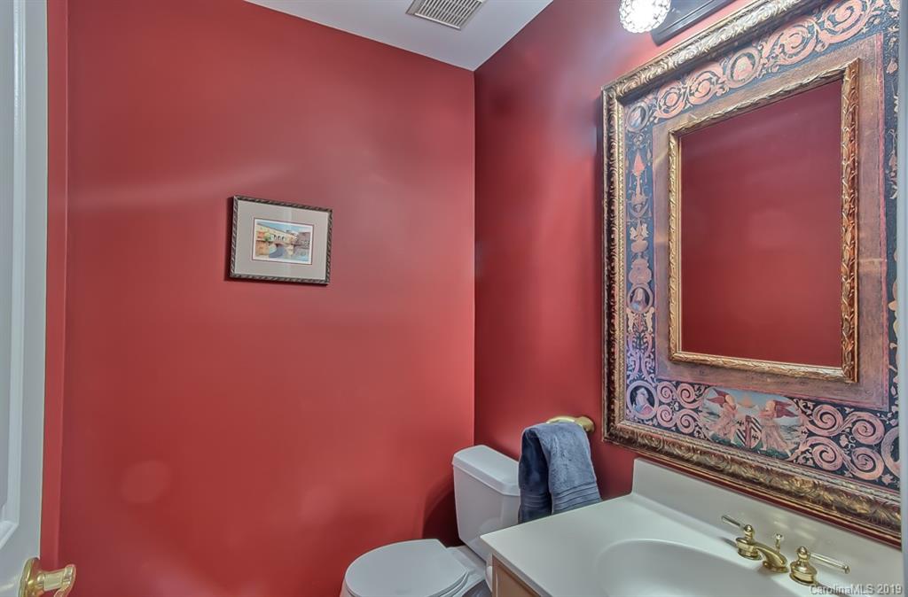 9731 Deer Spring Lane Charlotte, NC 28210 - Photo 11 of 26 a bathroom with a toilet a sink and mirror