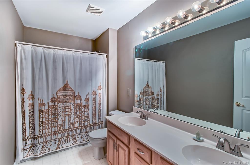 9731 Deer Spring Lane Charlotte, NC 28210 - Photo 15 of 26 a bathroom with a toilet a sink and mirror