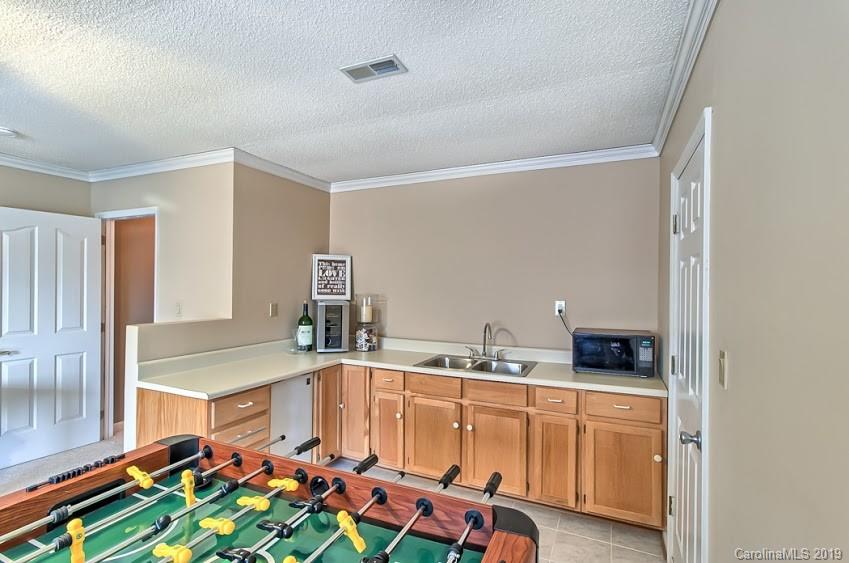 9731 Deer Spring Lane Charlotte, NC 28210 - Photo 17 of 26 a room with stainless steel appliances kitchen island granite countertop a sink and cabinets