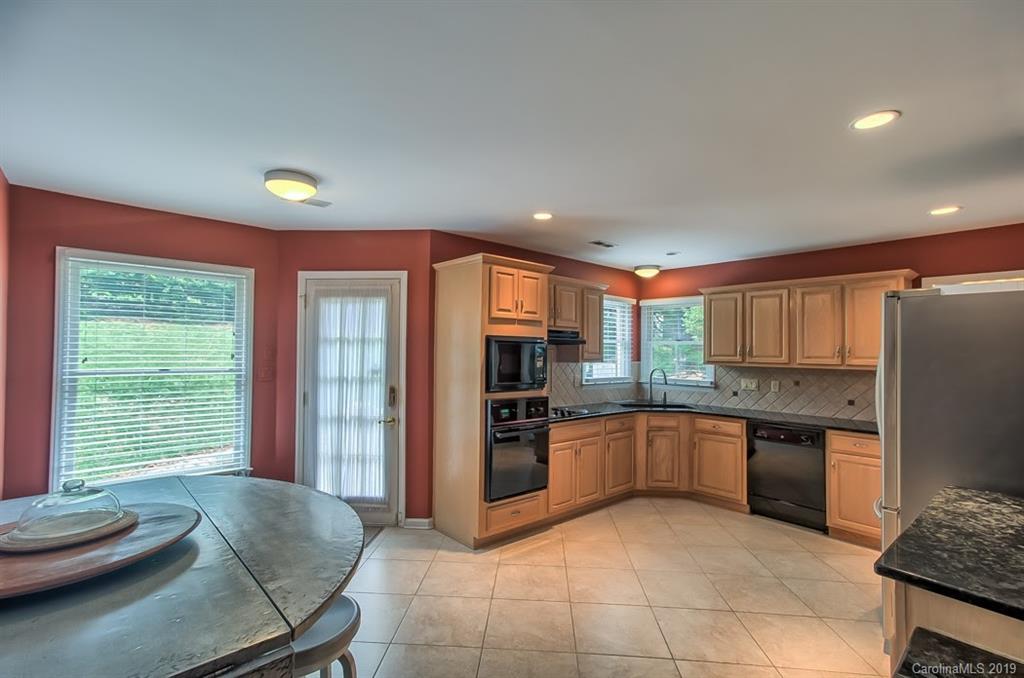 9731 Deer Spring Lane Charlotte, NC 28210 - Photo 6 of 26 a large kitchen with kitchen island granite countertop a large counter top space appliances and a window