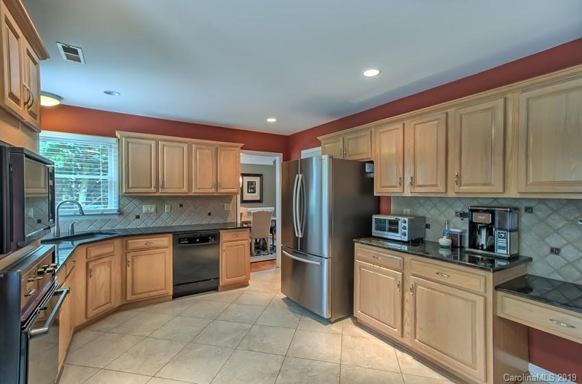9731 Deer Spring Lane Charlotte, NC 28210 - Photo 7 of 26 a kitchen with stainless steel appliances granite countertop a refrigerator sink and cabinets