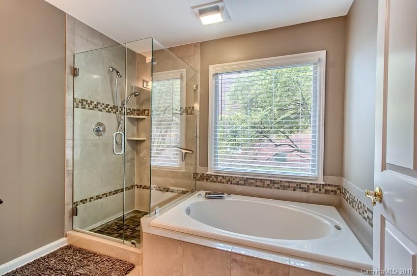 9731 Deer Spring Lane Charlotte, NC 28210 - Photo 10 of 26 a bathroom with a tub a window and a shower
