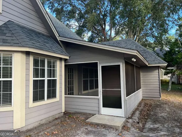 a view of a house with a large window and wooden fence