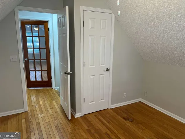 an empty room with wooden floor and closet