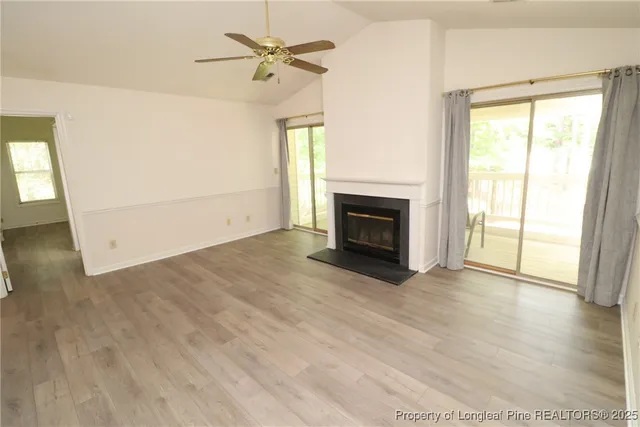 an empty room with windows fireplace and a sink