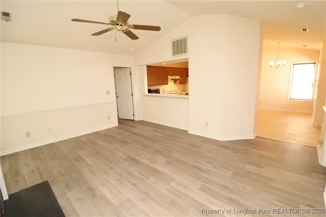 a view of a bedroom with wooden floor and a ceiling fan