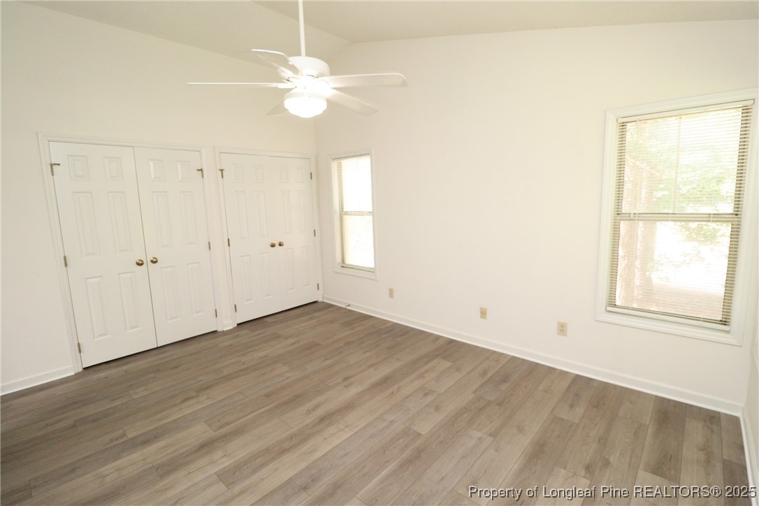 6120 Sunpointe Drive, Unit 205 Raleigh, NC 27606 - Photo 19 of 32 an empty room with wooden floor fan and windows