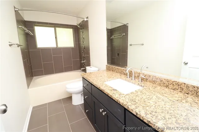 a bathroom with a granite countertop sink a toilet and bathtub