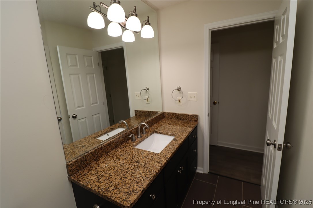 6120 Sunpointe Drive, Unit 205 Raleigh, NC 27606 - Photo 24 of 32 a bathroom with a granite countertop sink and a mirror