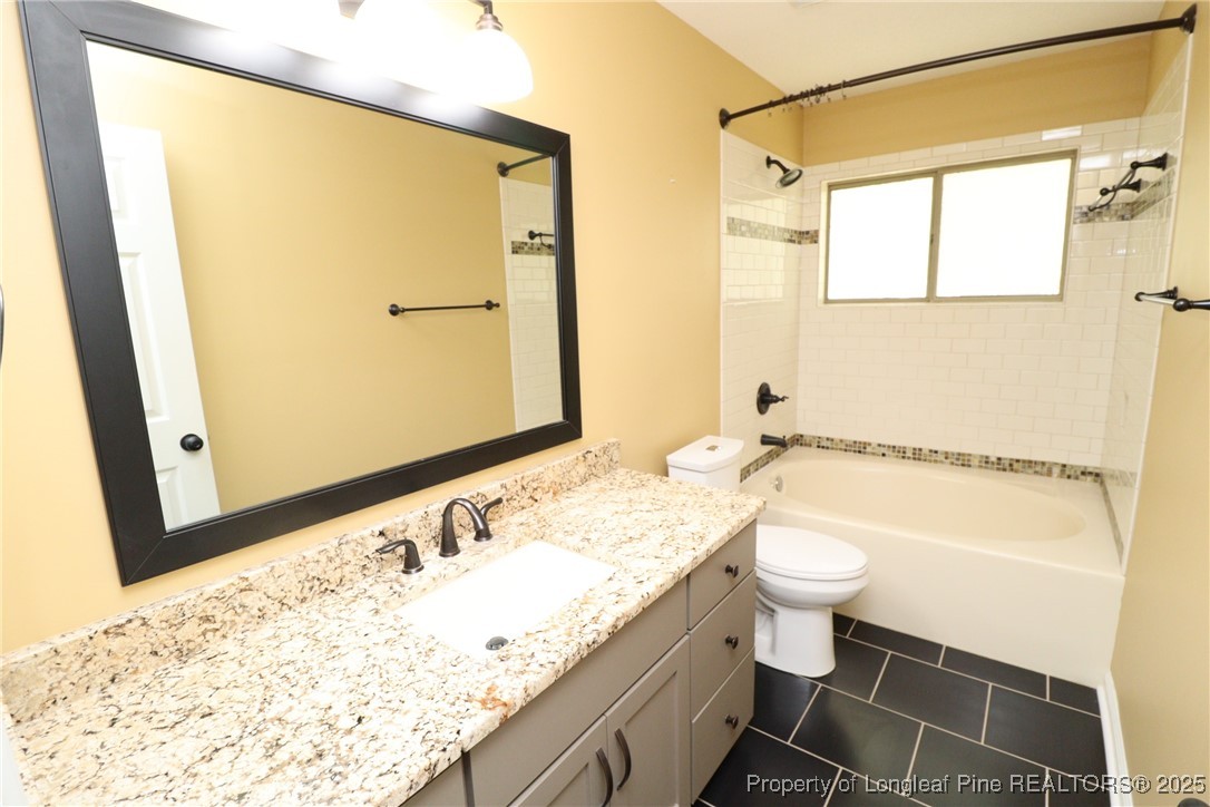 6120 Sunpointe Drive, Unit 205 Raleigh, NC 27606 - Photo 28 of 32 a bathroom with a granite countertop sink toilet and shower
