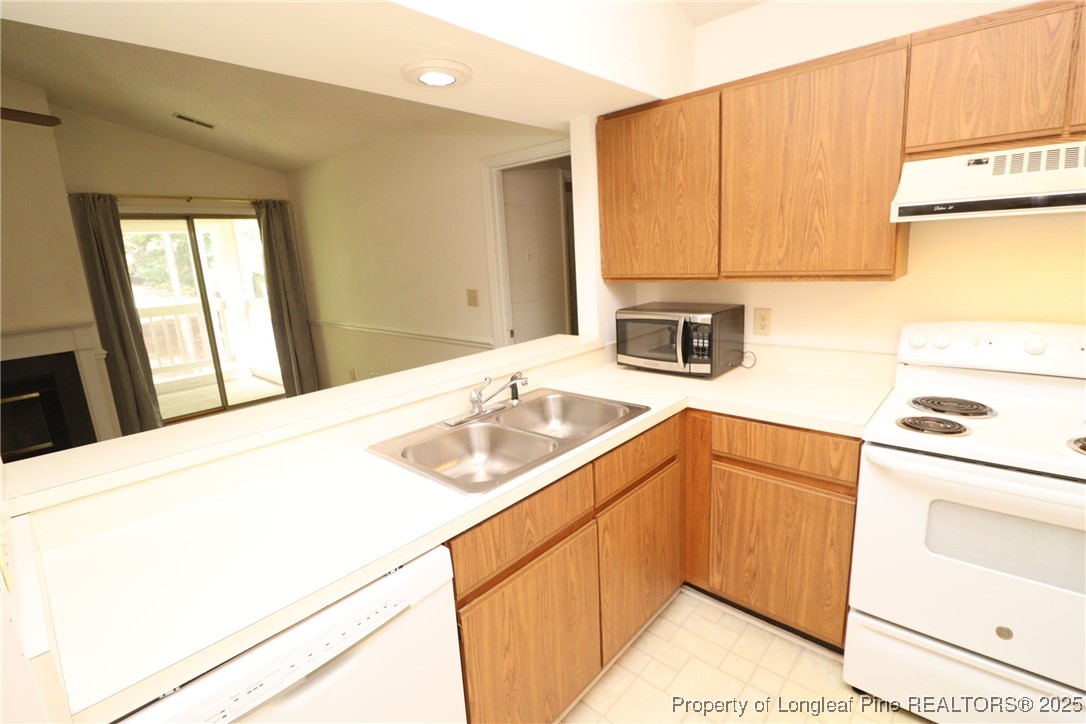 6120 Sunpointe Drive, Unit 205 Raleigh, NC 27606 - Photo 7 of 32 a kitchen with a sink a stove and cabinets