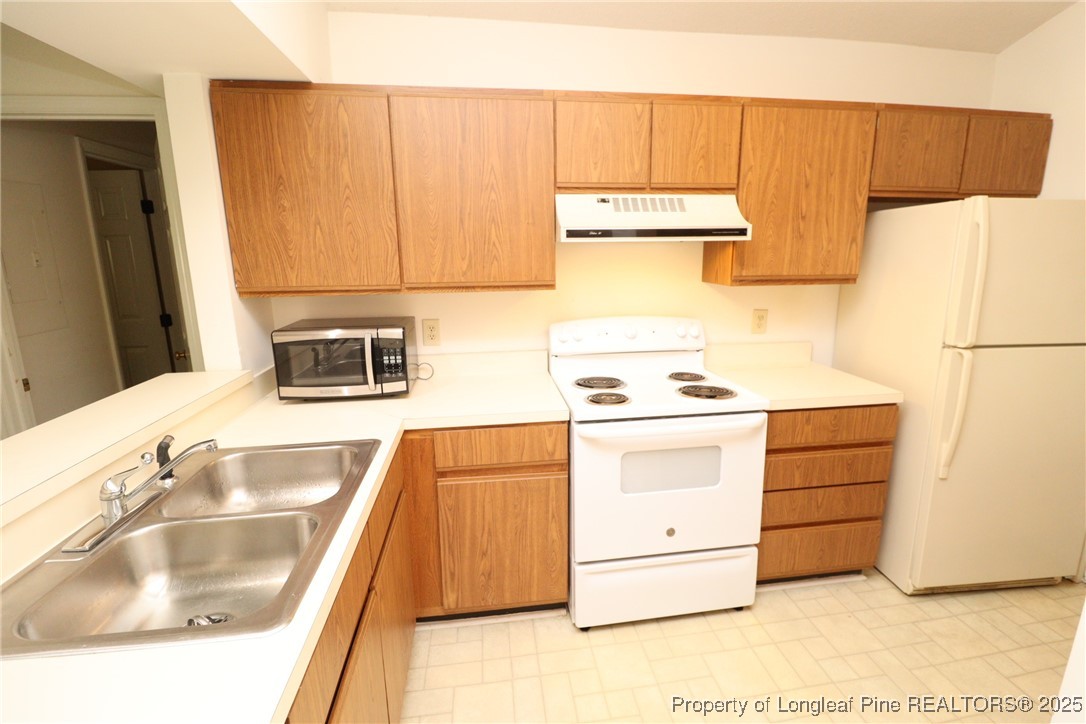 6120 Sunpointe Drive, Unit 205 Raleigh, NC 27606 - Photo 8 of 32 a kitchen with a refrigerator and a sink