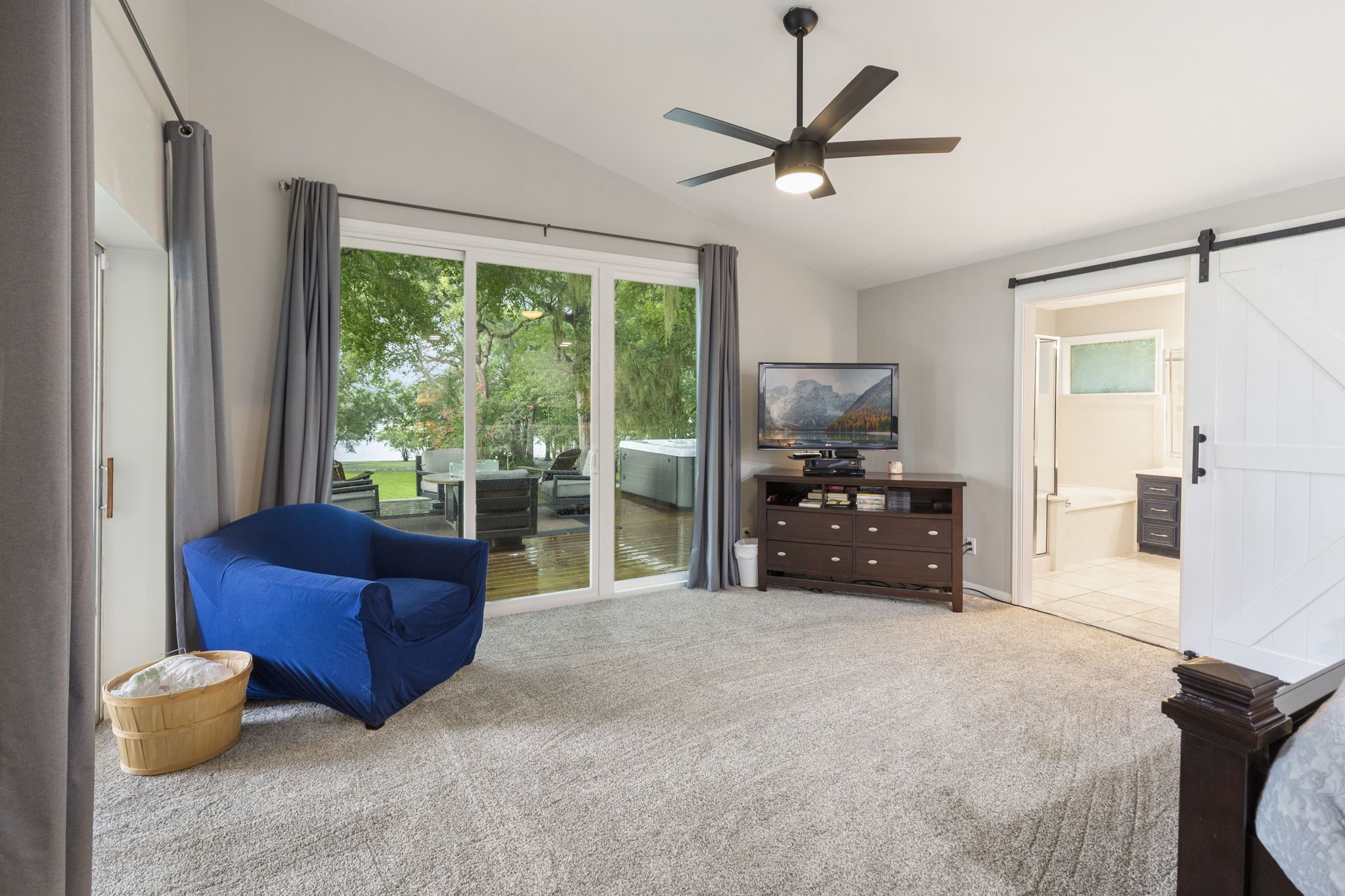 245 Lakeland Road Huntsville, TX 77320 - Photo 20 of 49 The expansive primary bedroom boasts large windows that offer a stunning view of the lake, creating a serene and picturesque retreat.