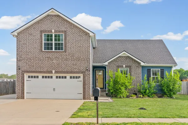 a front view of a house with a yard and garage