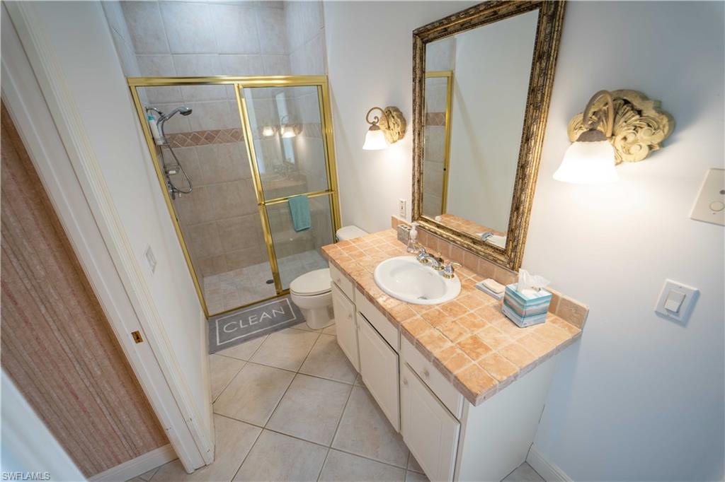 5886 Paradise Circle Naples, FL 34110 - Photo 12 of 19 Bathroom featuring tile patterned flooring, walk in shower, vanity, and toilet