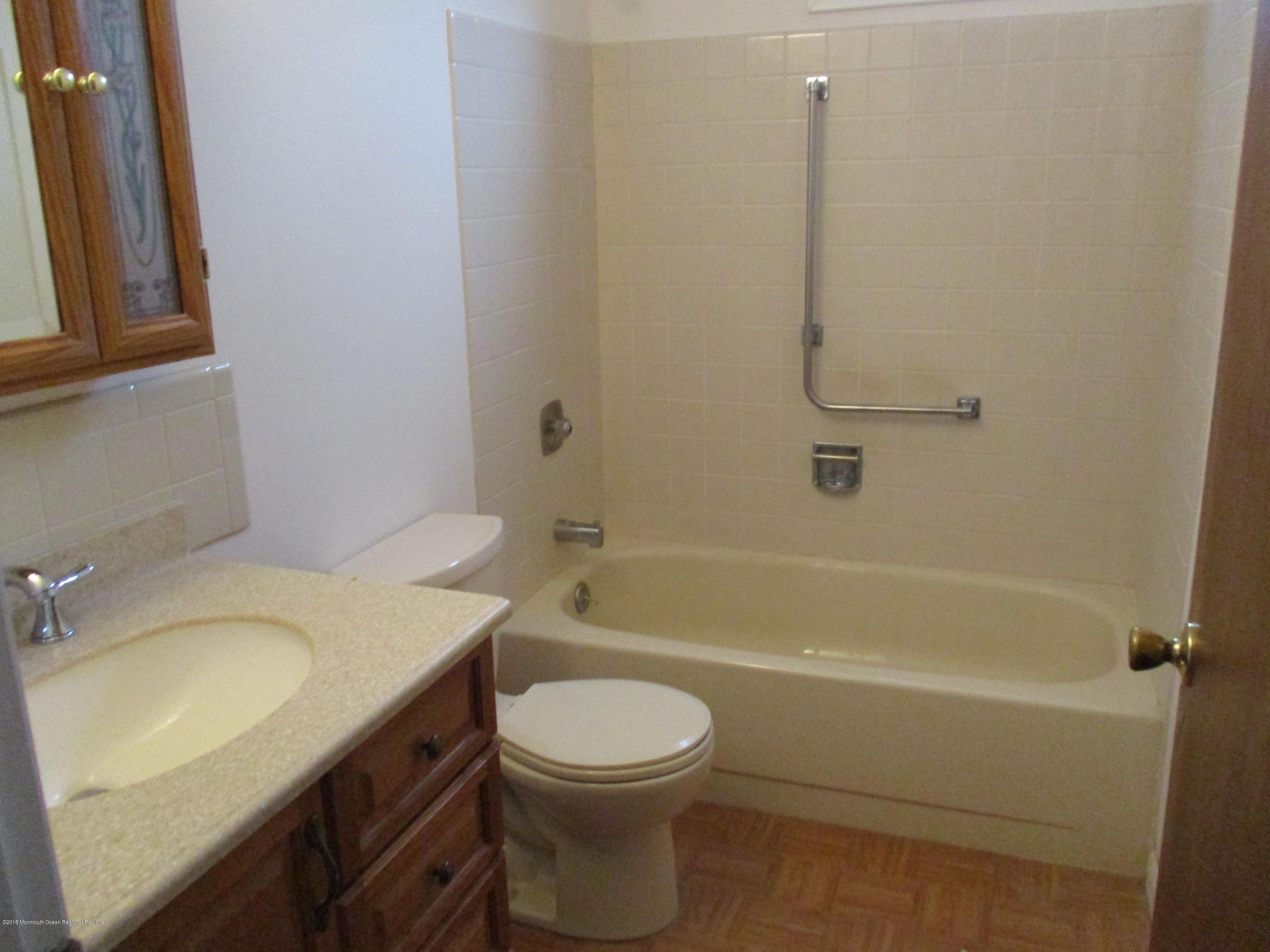 85 Sunset Road, Unit 60 Whiting, NJ 08759 - Photo 11 of 18 a bathroom with a granite countertop toilet a sink and bathtub