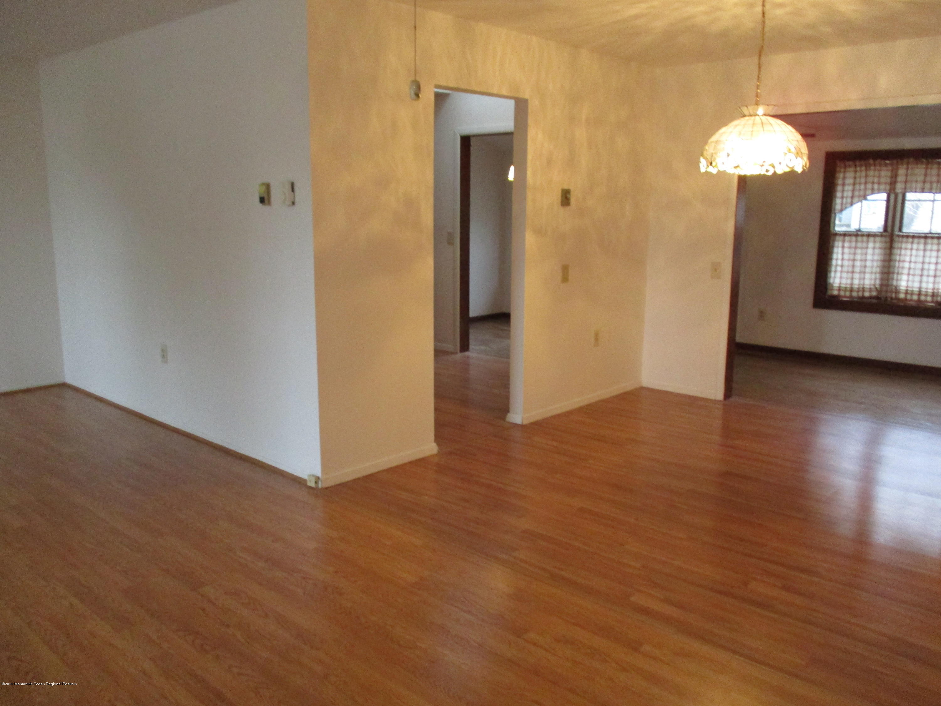 85 Sunset Road, Unit 60 Whiting, NJ 08759 - Photo 12 of 18 an empty room with wooden floor and mirror
