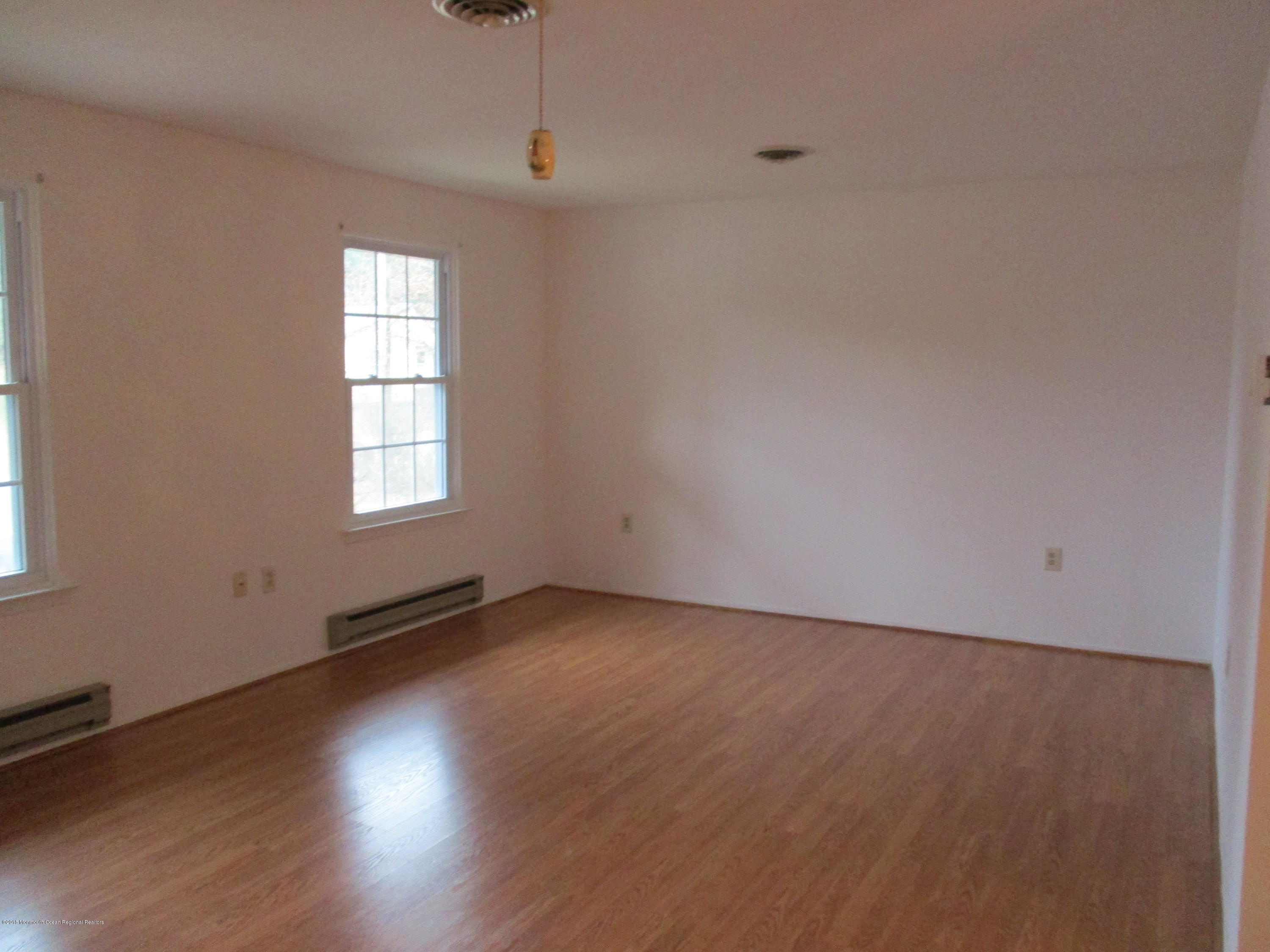 85 Sunset Road, Unit 60 Whiting, NJ 08759 - Photo 5 of 18 an empty room with wooden floor and windows