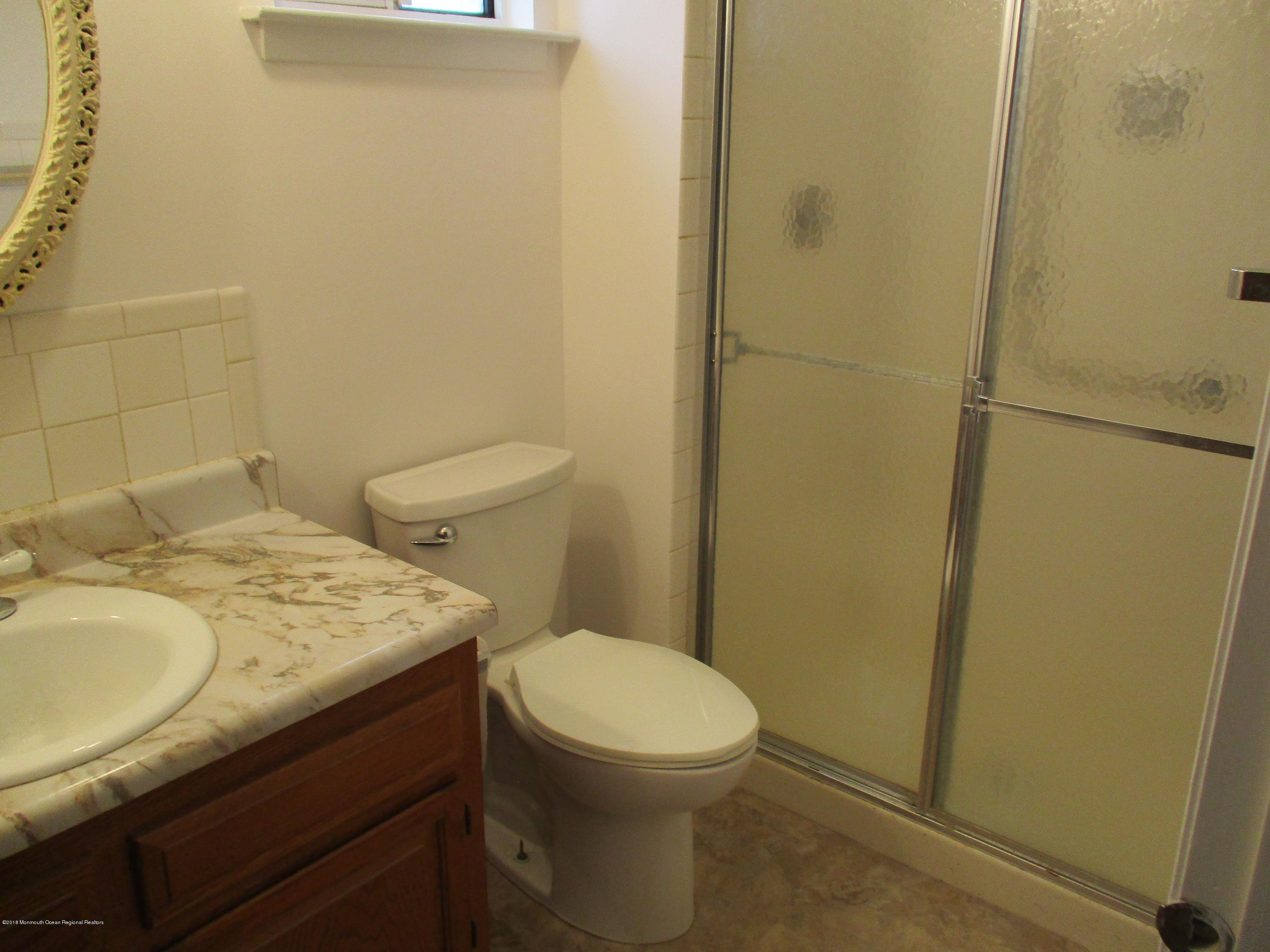 85 Sunset Road, Unit 60 Whiting, NJ 08759 - Photo 8 of 18 a bathroom with a granite countertop toilet and sink
