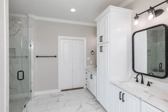 a bathroom with a double vanity sink mirror and shower