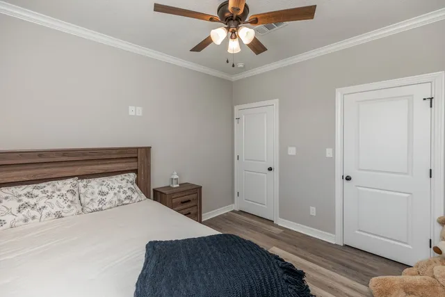 a bedroom with a bed and a chandelier fan