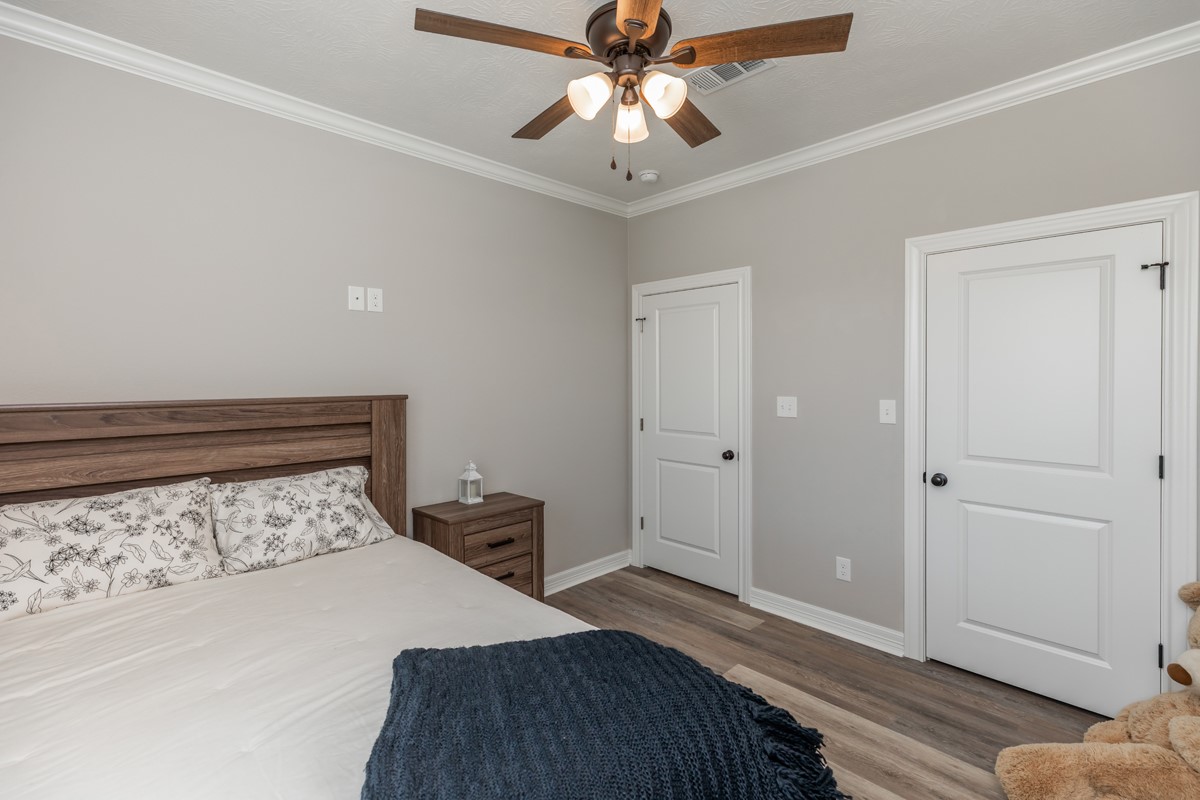 1880 Brenner Boulevard Lumberton, TX 77657 - Photo 25 of 32 a bedroom with a bed and a chandelier fan