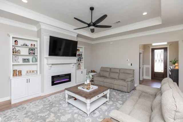 a living room with furniture a flat screen tv and a fireplace