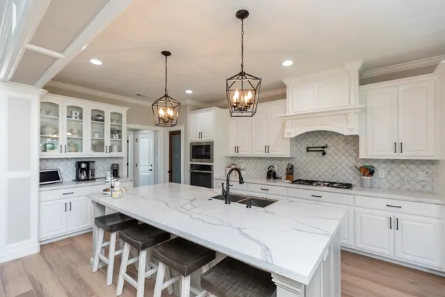 a kitchen with stainless steel appliances a kitchen island a stove a table and chairs in it
