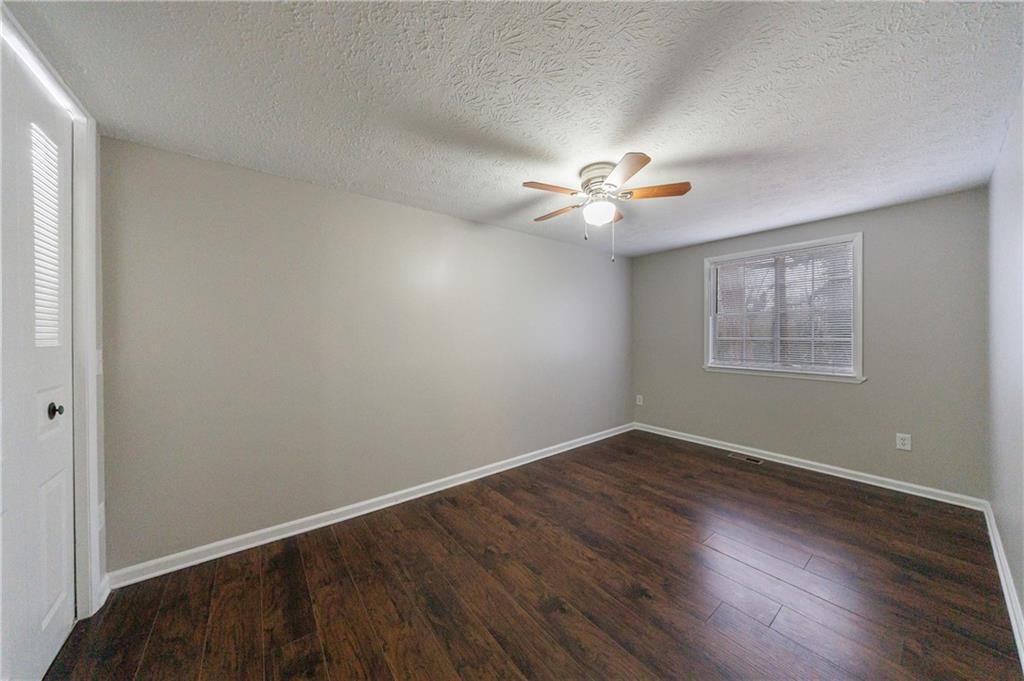 1960 Hamilton Place Southeast Marietta, GA 30067 - Photo 19 of 22 an empty room with wooden floor chandelier fan and windows
