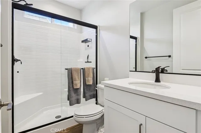 a bathroom with a sink a toilet and shower