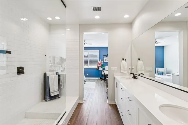 a bathroom with a double vanity sink a mirror and a shower