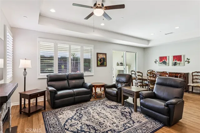 a living room with furniture ceiling fan and a window