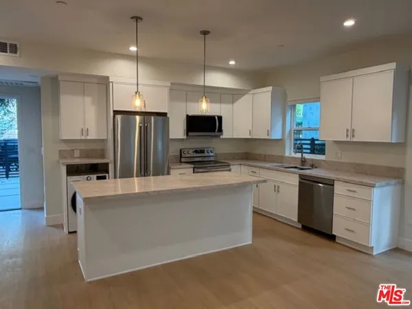 a kitchen with stainless steel appliances a refrigerator and a counter top space