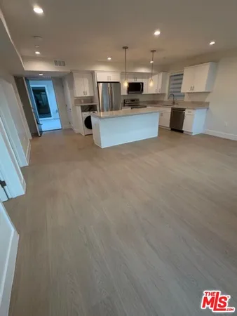 a kitchen with stainless steel appliances granite countertop a sink a stove and a refrigerator