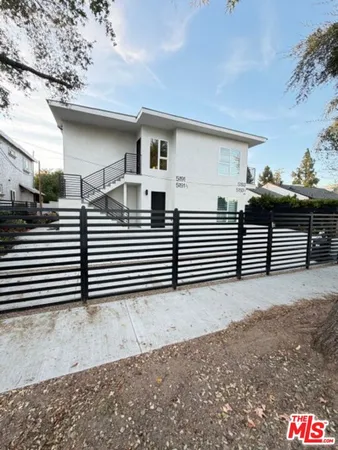 a view of a house with wooden fence