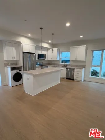 a large kitchen with kitchen island a stove a sink dishwasher and a refrigerator