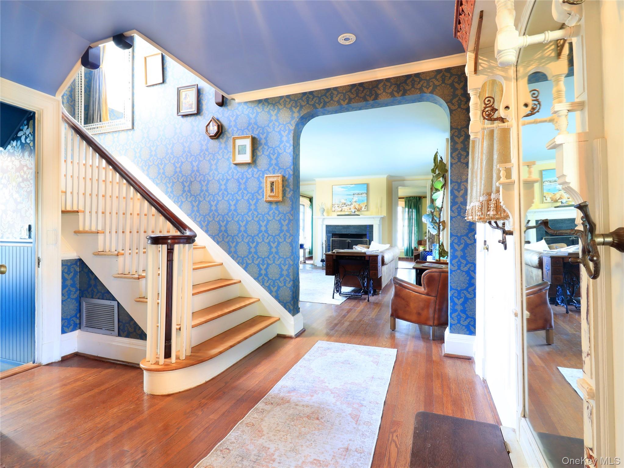 11-20 Shore Road Queens, NY 11363 - Photo 23 of 45 Hardwood flooring extends throughout this entryway featuring a staircase with white spindles and a dark wood handrail