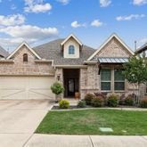 a front view of a house with a garden and plants
