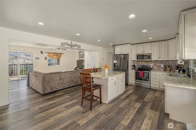 a kitchen with stainless steel appliances granite countertop a refrigerator sink and cabinets
