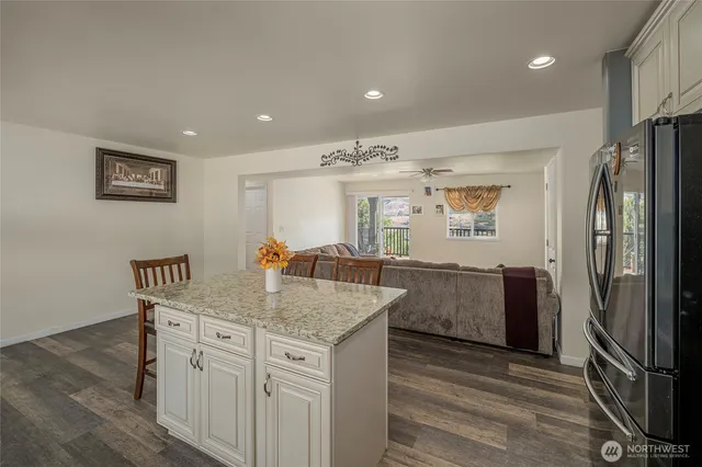 a kitchen with stainless steel appliances granite countertop a refrigerator a sink and a stove