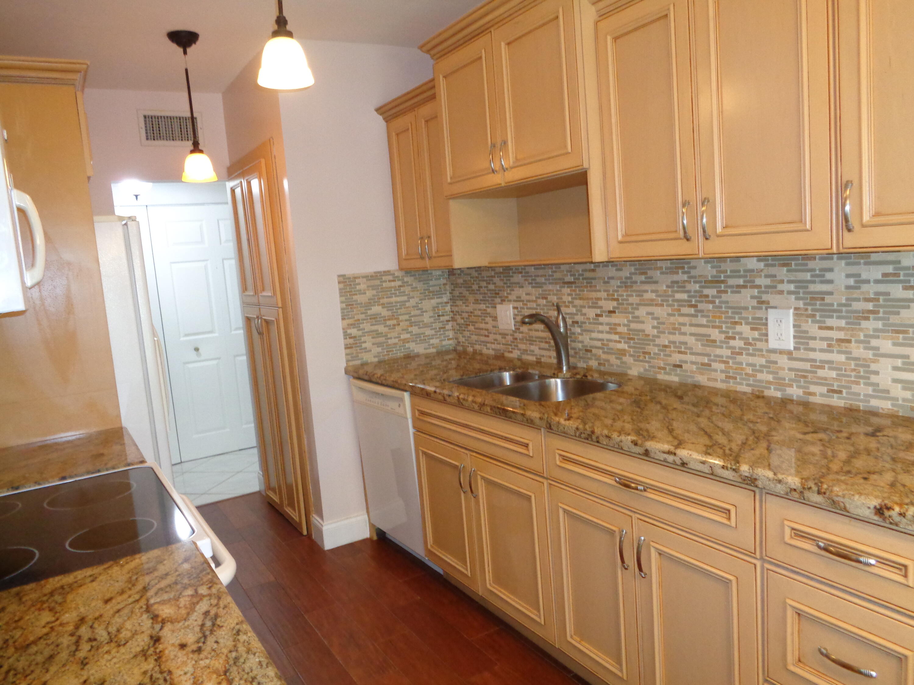 6328 Longboat Lane West, Unit 201 Boca Raton, FL 33433 - Photo 3 of 16 a kitchen with cabinets and a wooden floor