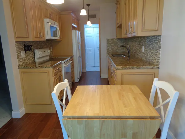 a kitchen with a sink a refrigerator and cabinets