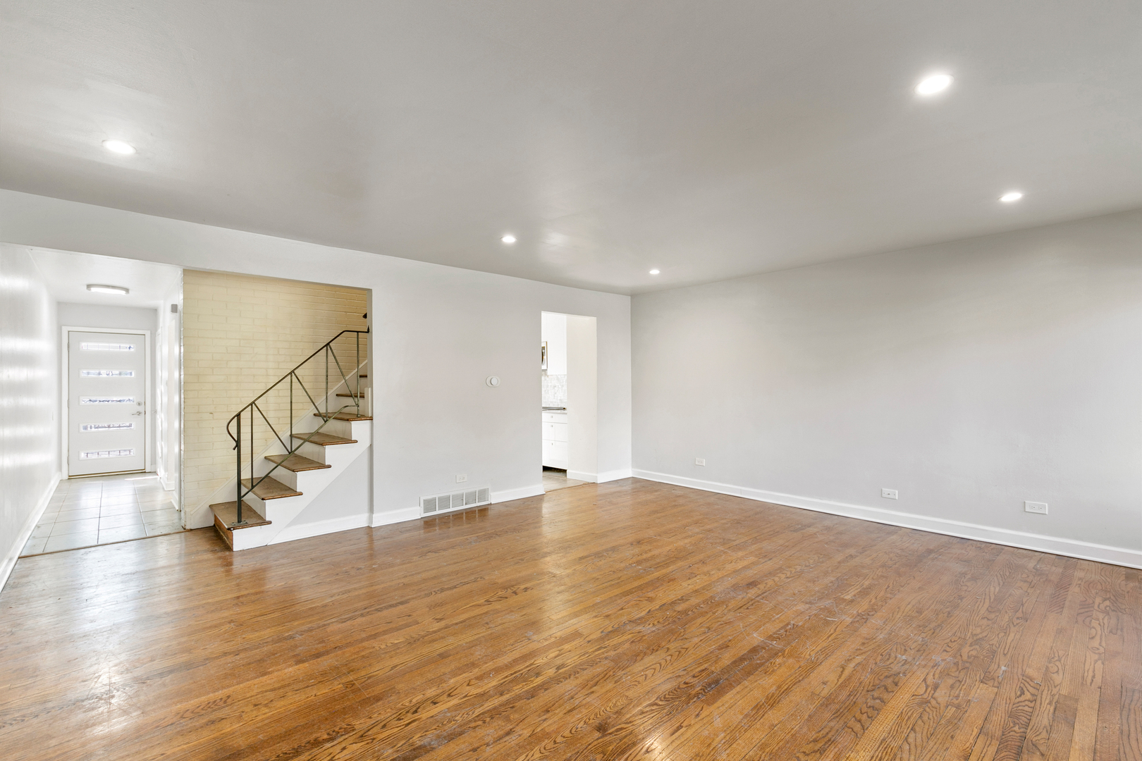 1731 East 74th Street Chicago, IL 60649 - Photo 4 of 19 an empty room with wooden floor and windows