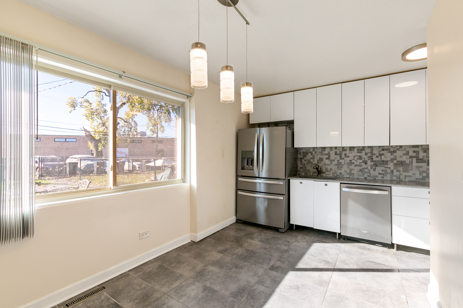 1731 East 74th Street Chicago, IL 60649 - Photo 5 of 19 a kitchen with a refrigerator and white cabinets