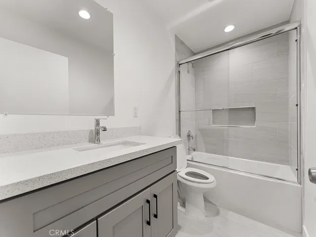 a bathroom with a granite countertop sink toilet and shower