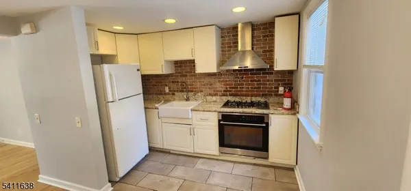 a kitchen with stainless steel appliances granite countertop a refrigerator and a stove