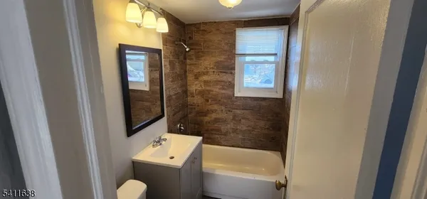 a bathroom with a bathtub shower sink and toilet