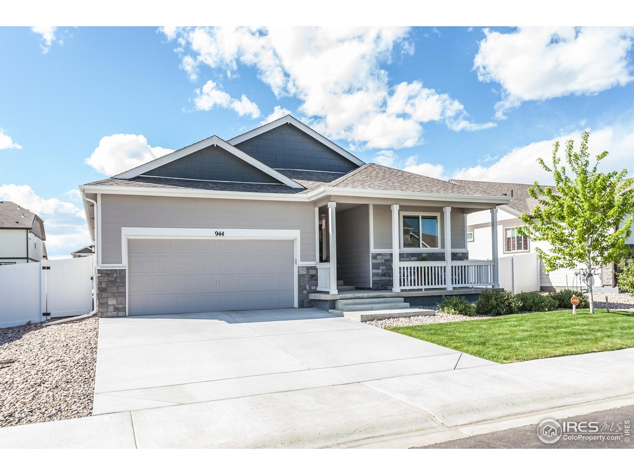 a front view of a house with a garden and trees